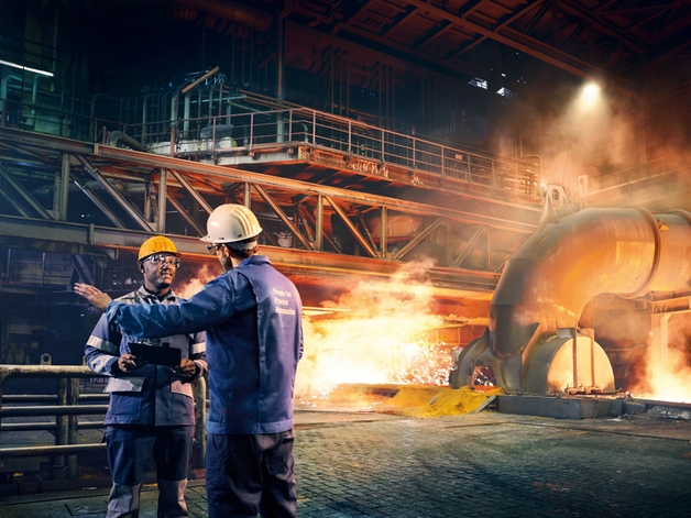 金属工場で議論する2人のエンジニア。